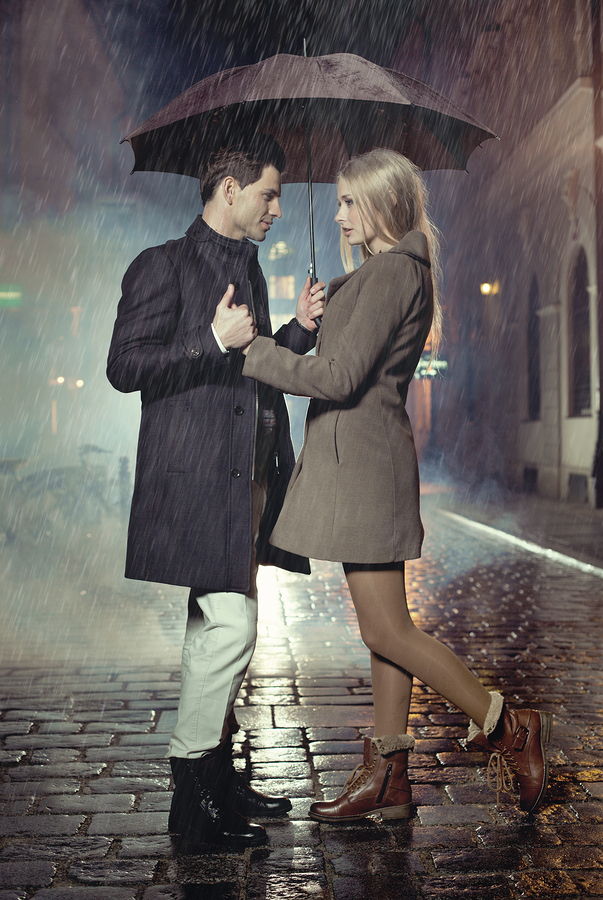 Couple sharing umbrella on a rainy evening